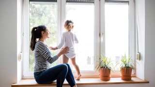Frau mit Kind schauen aus dem Fenster. Frau mit Kind schauen aus dem Fenster.